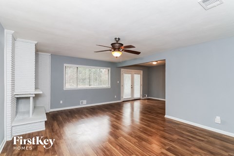 a living room with wood floors and a ceiling fan
