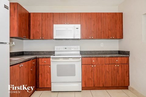 A kitchen with wooden cabinets and a white oven.