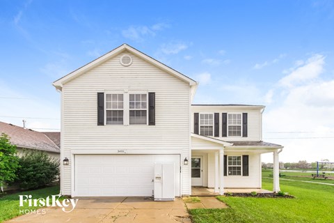 A white house with a garage is for sale.