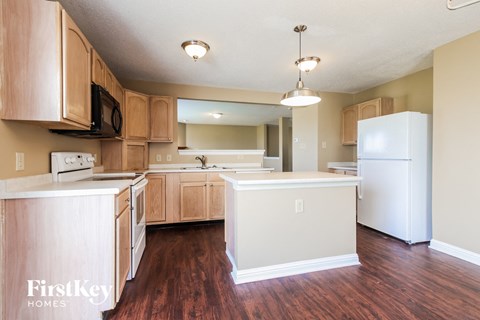 A kitchen with wooden cabinets and a white fridge.