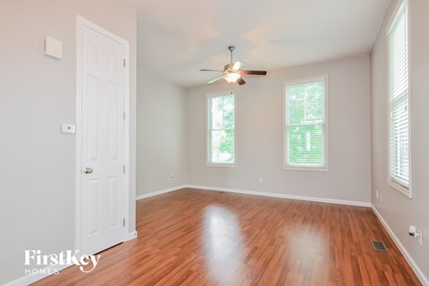 A room with a wooden floor and a ceiling fan.