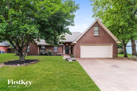 A brick house with a garage is for sale.
