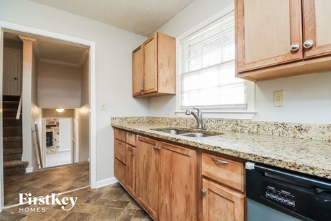 A kitchen with wooden cabinets and granite countertops.