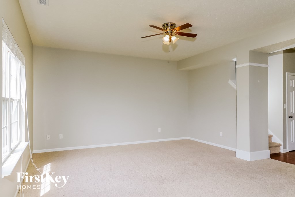 a empty living room with a ceiling fan