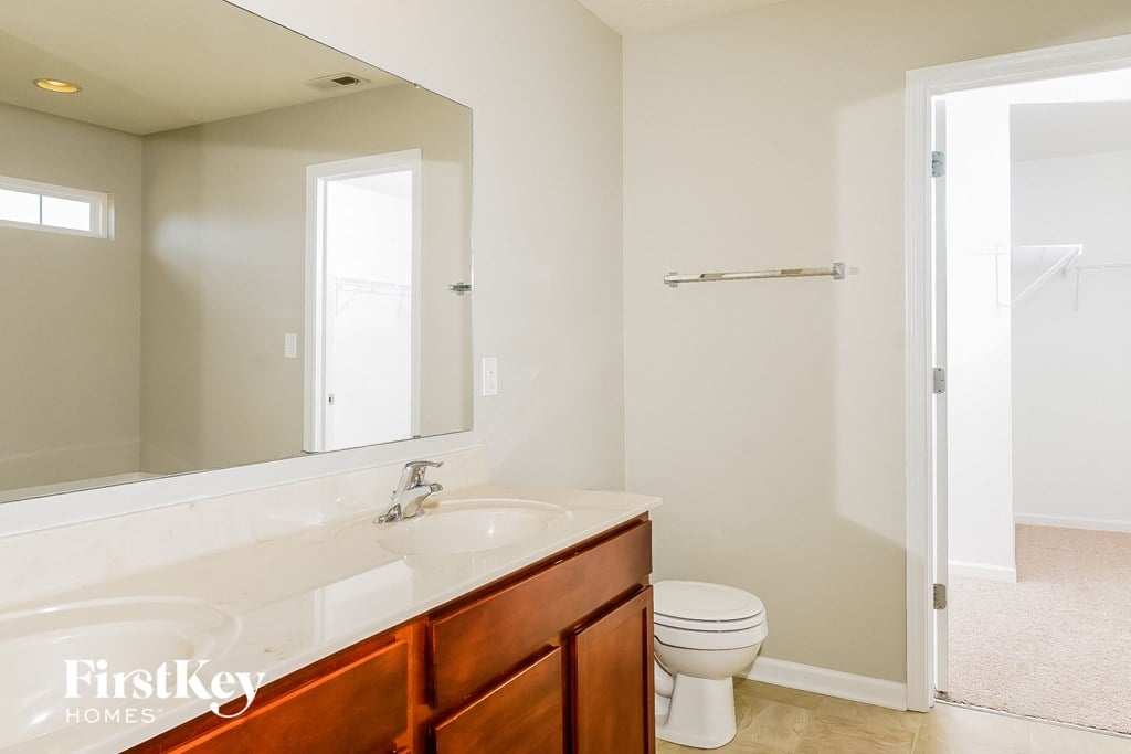 a bathroom with a toilet and a sink and a mirror