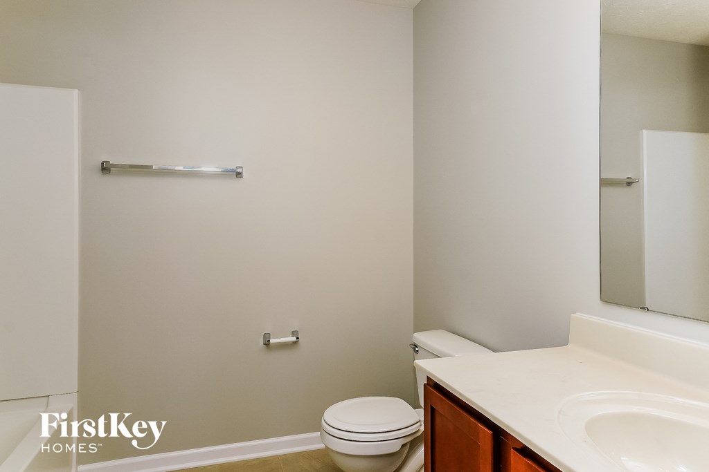 a bathroom with a toilet and a sink and a mirror