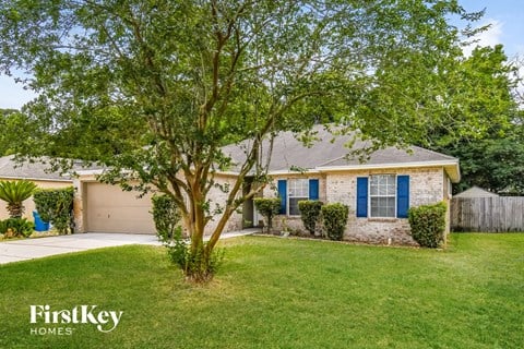 a home with blue shutters and a tree in the front yard