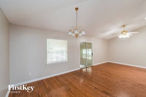 a living room with a wood floor and a chandelier