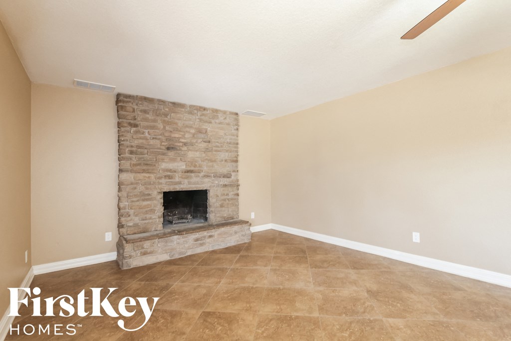 the living room has a brick fireplace and tile flooring