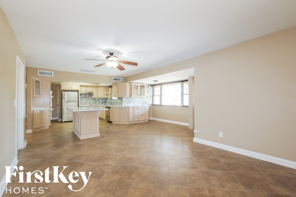 an open kitchen and living room with a ceiling fan