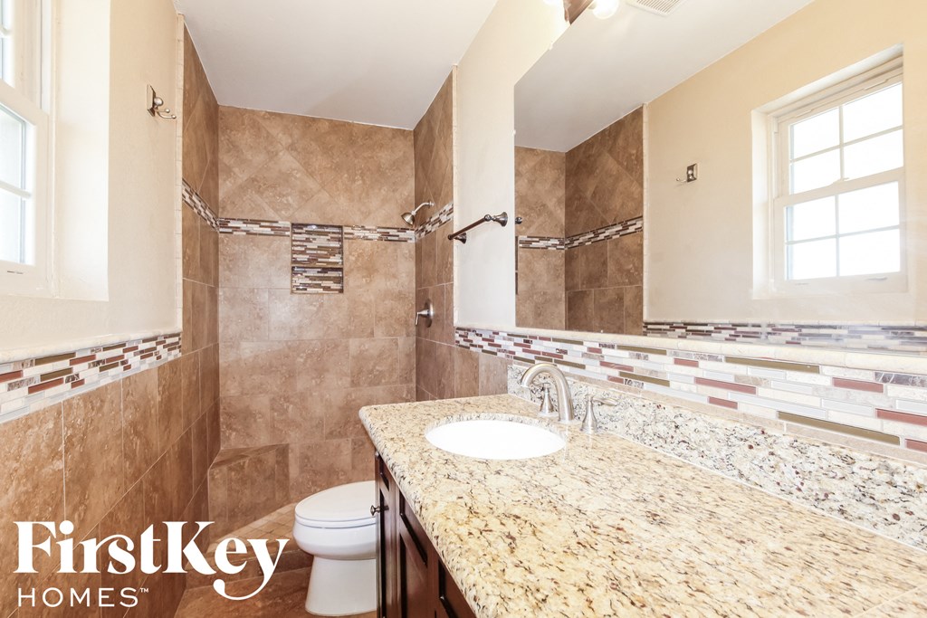 a bathroom with a sink and shower and a toilet