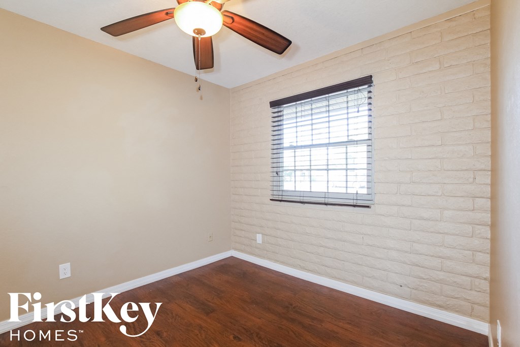 an empty room with a ceiling fan and a window