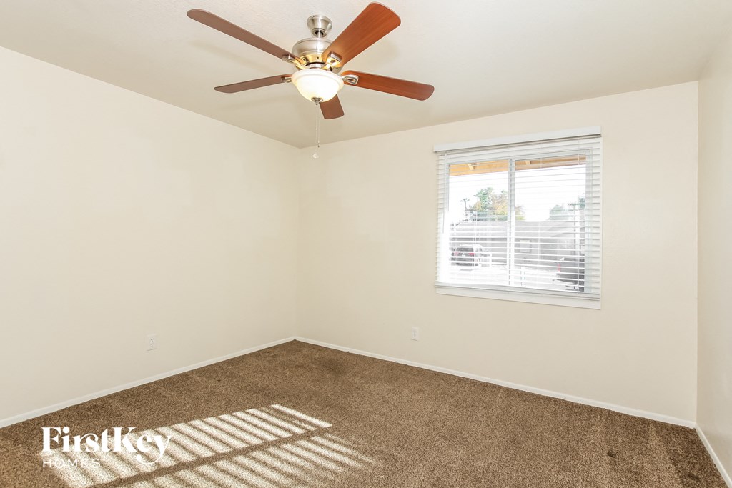 a bedroom with a ceiling fan and a window