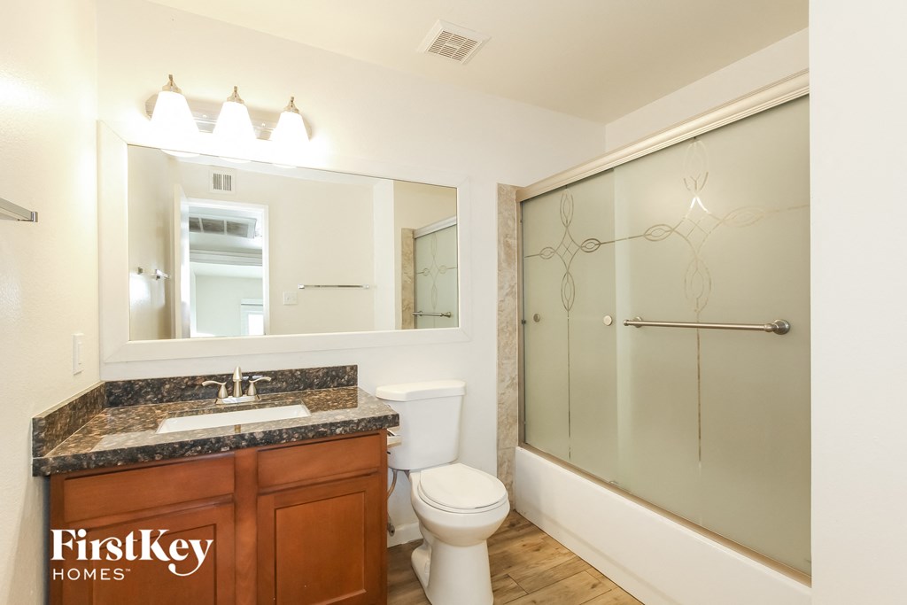 a bathroom with a sink toilet and shower and a mirror