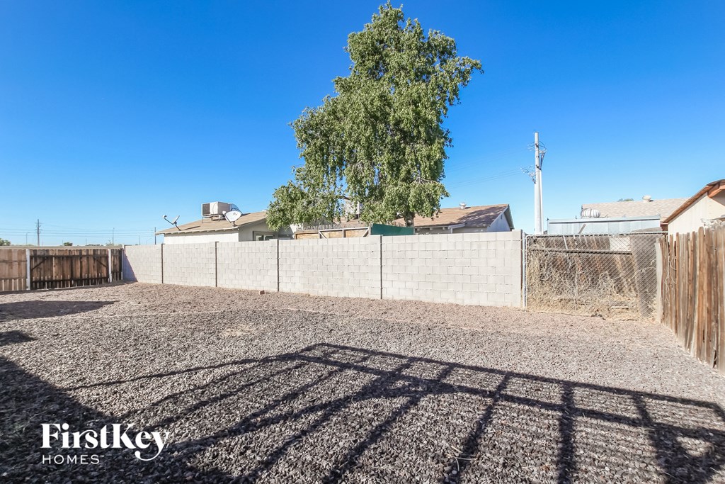 a large yard with a fence and a tree