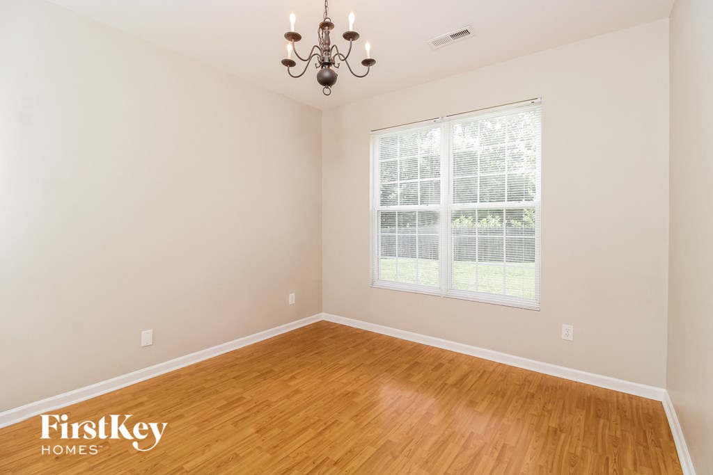 the living room of a home with wood floors and a large window