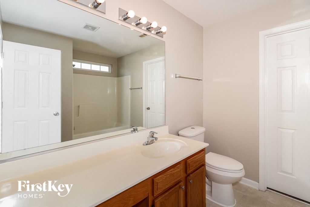 a bathroom with a mirror and a sink and a toilet