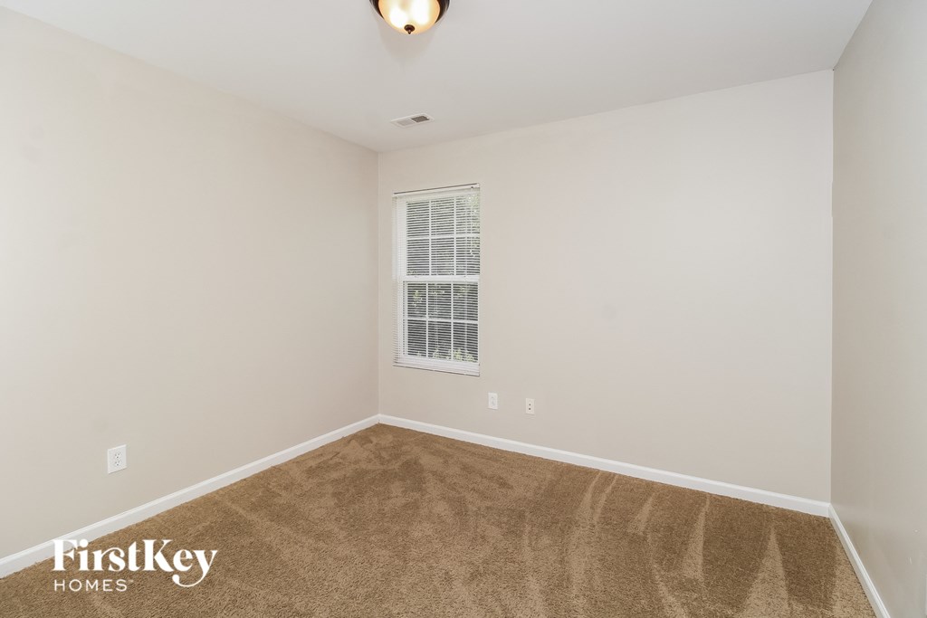 a spacious living room with carpet and a window