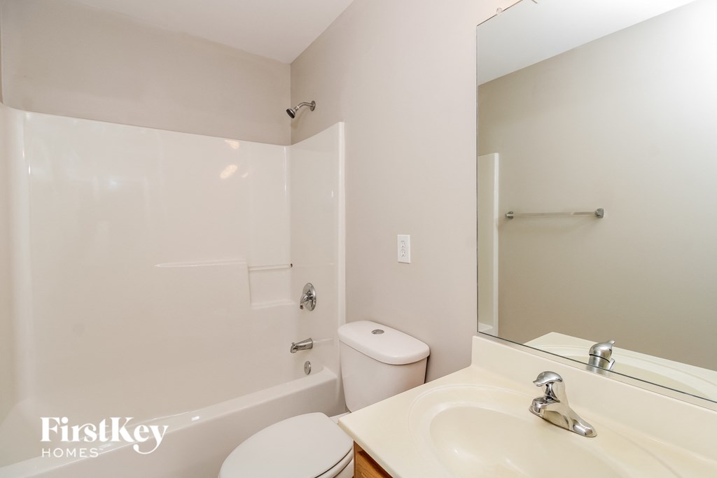 a bathroom with a sink toilet and shower and a mirror