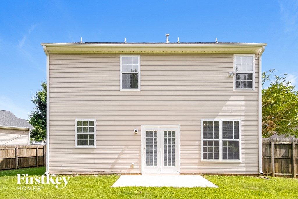 the outside of a house with a lawn and a fence