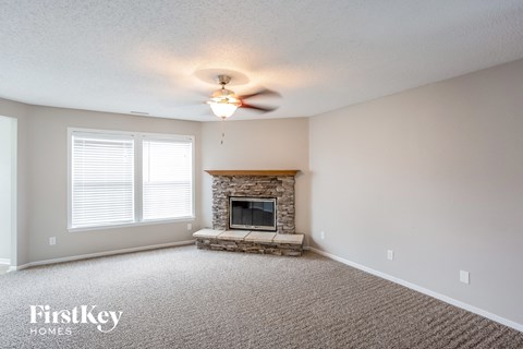A living room with a fireplace and a carpet.