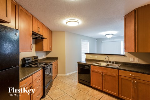 A kitchen with wooden cabinets and black appliances.