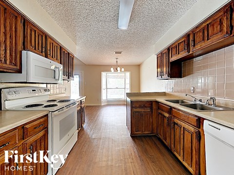 A kitchen with wooden cabinets and a stove top oven.