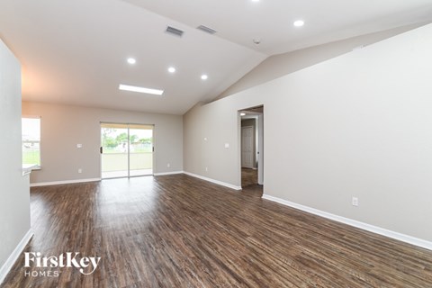 A spacious room with wooden floors and a slanted ceiling.