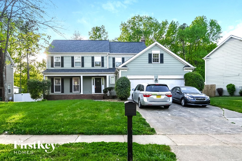 a house with two cars parked in front of it