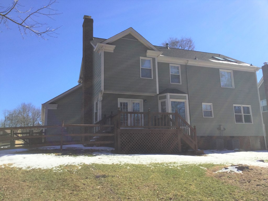 the back of the house with a deck and a fence