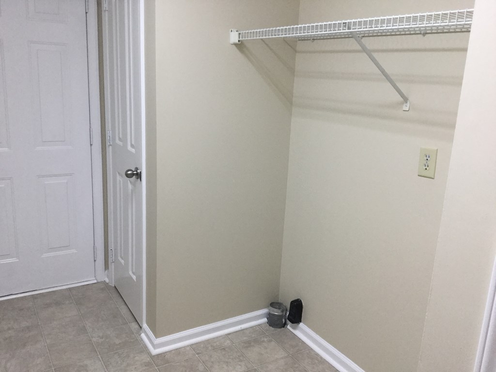 an empty closet with a white door and a white closet door with a shoe rack