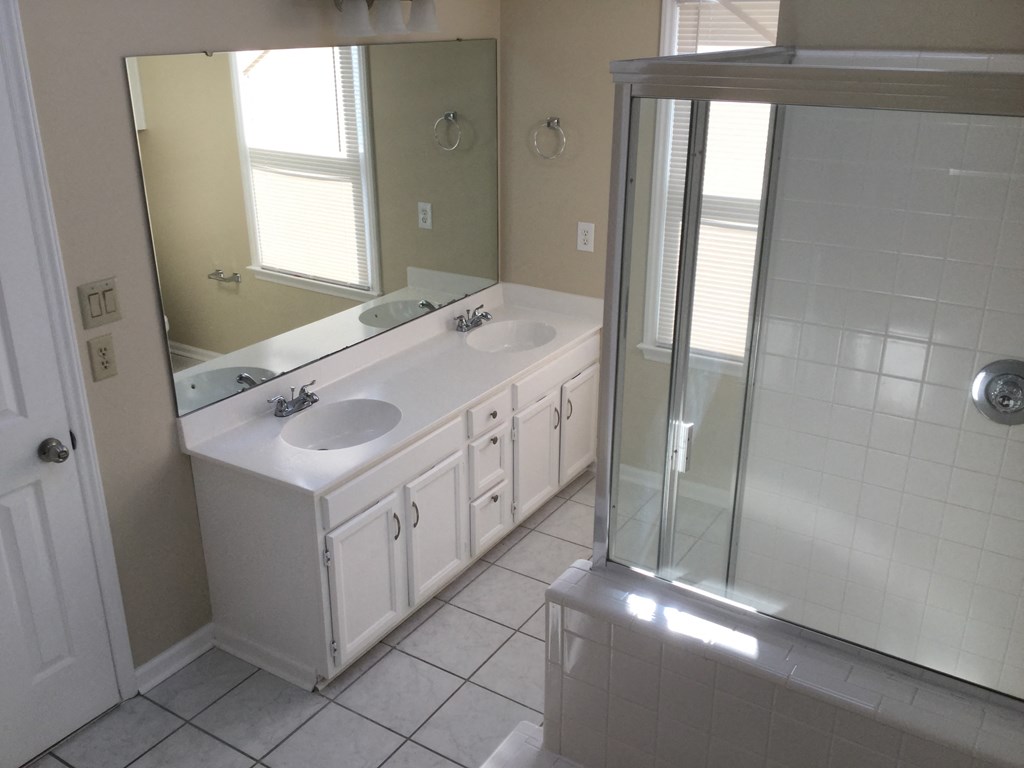 a bathroom with two sinks and a shower