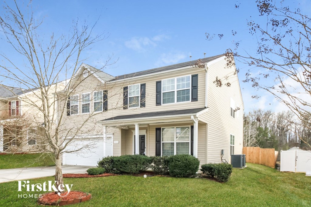 A house with a white siding and a brown roof is shown with the words "FirstKey Homes" on the bottom left.