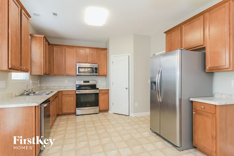 A kitchen with wooden cabinets and a stainless steel refrigerator.