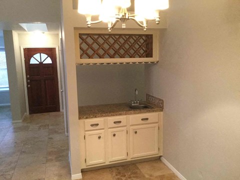 A kitchen with a sink and cabinets under a window.