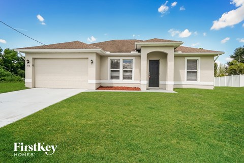 a beige house with a lawn in front of it