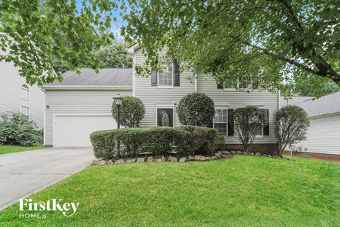 a white house with a lawn and a driveway