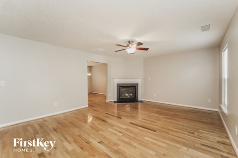 a living room with a fireplace and wooden floors