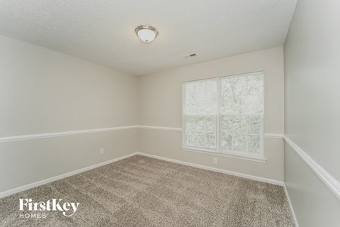 the bedroom of a home with a carpeted floor and a window