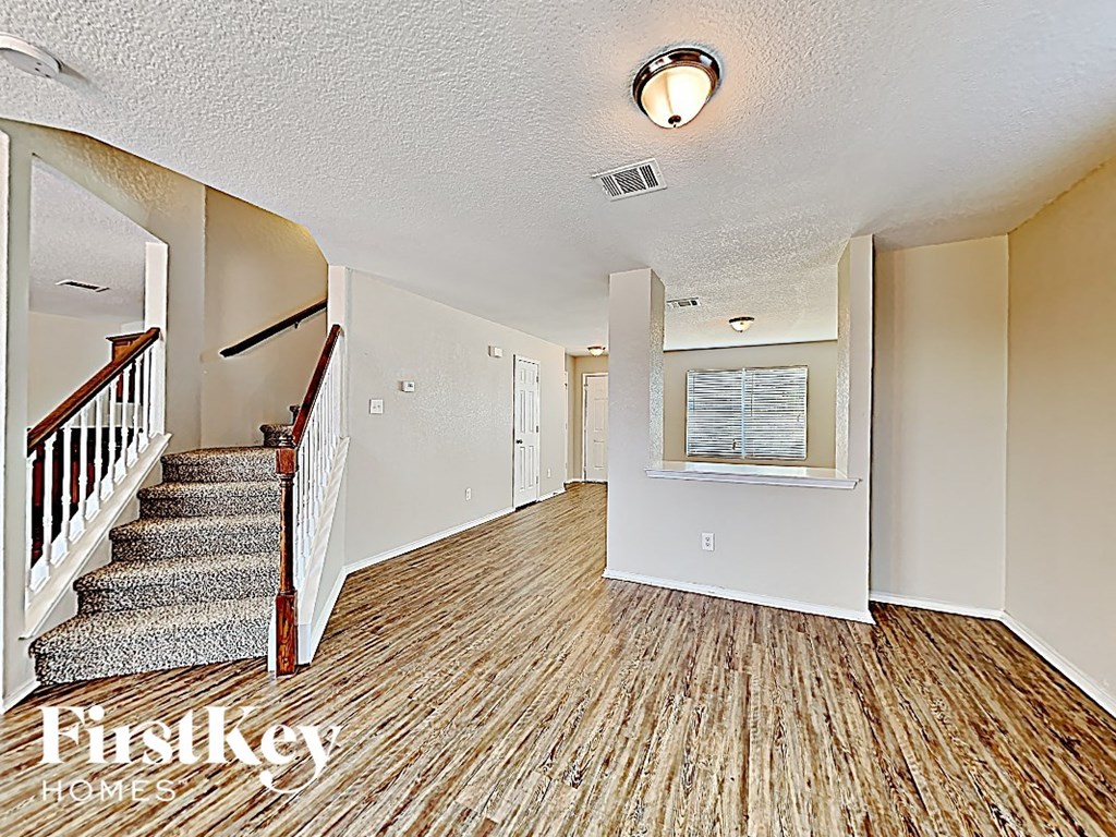 a living room with wood floors and a staircase