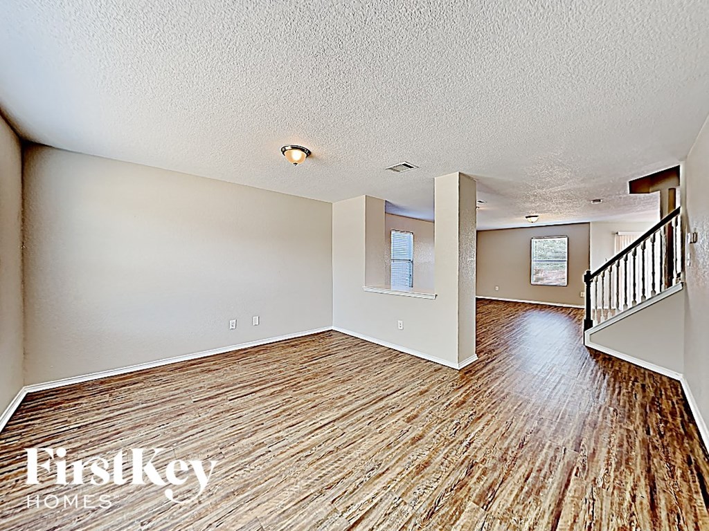a living room with a wood floor and a staircase