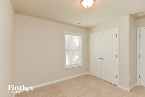 a bedroom with a closet and a door and a window