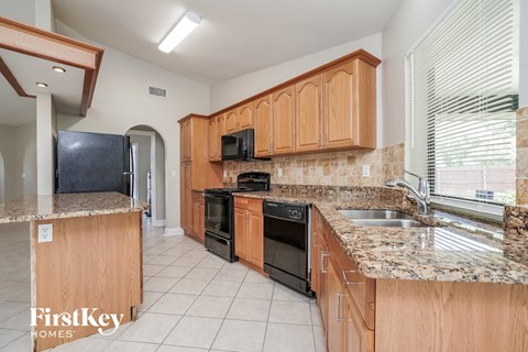 A kitchen with wooden cabinets and granite countertops.
