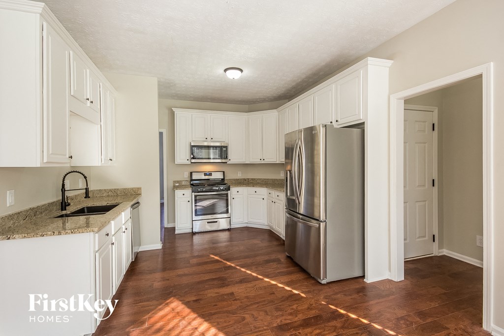 a kitchen with white cabinets and stainless steel appliances