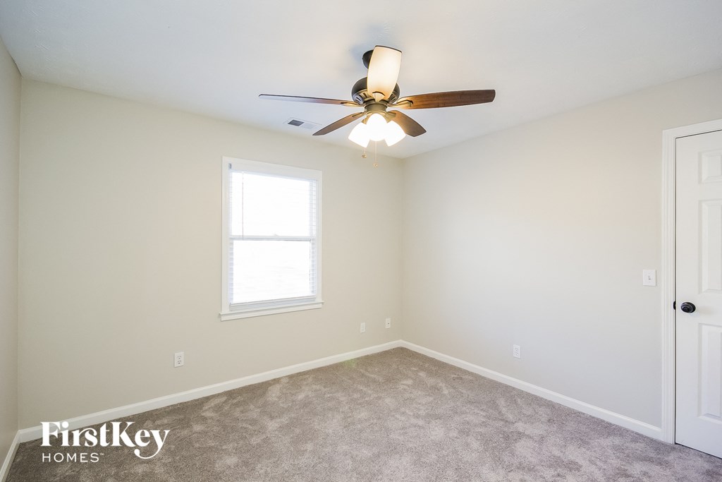 a bedroom with a ceiling fan and a window
