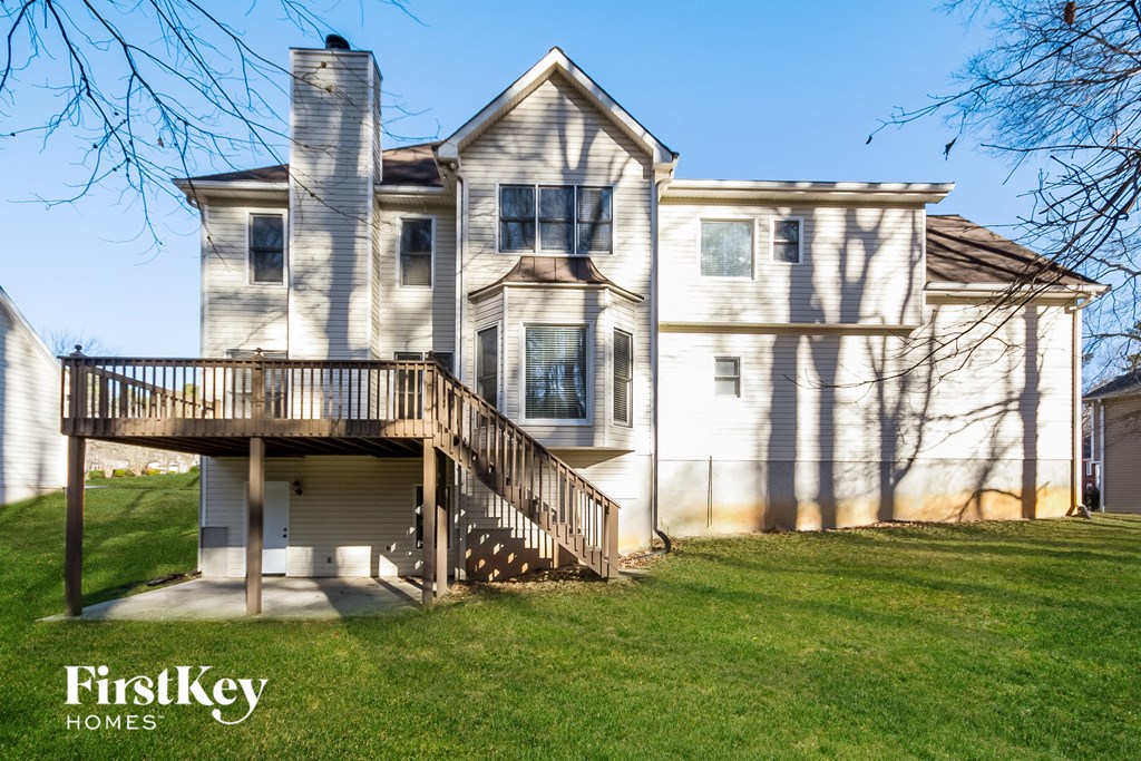 a large white house with a deck on the side of it