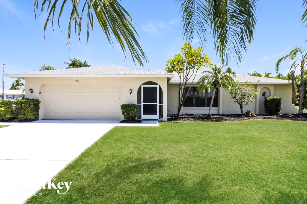 a white house with a lawn and a garage door