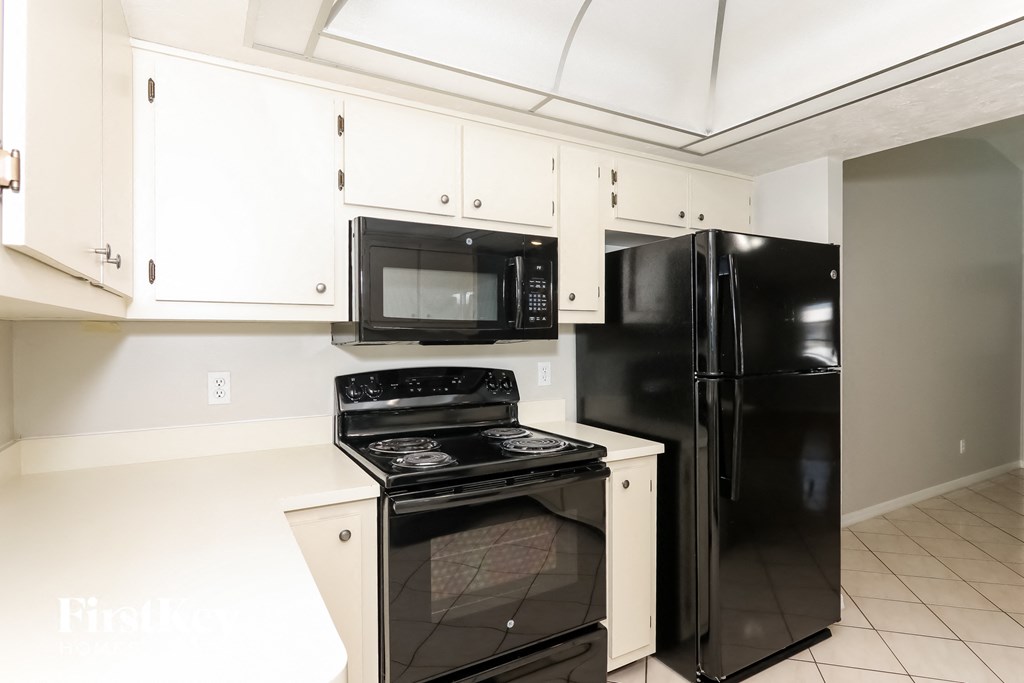 a kitchen with black appliances and white cabinets