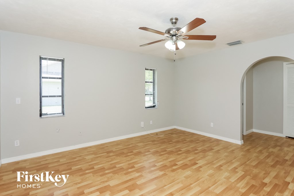 a living room with wood flooring and a ceiling fan