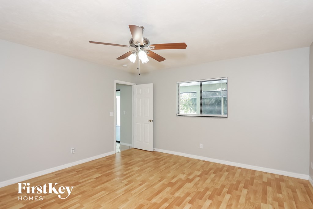 a living room with wood floors and a ceiling fan